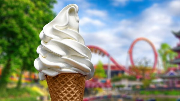 Soft ice cream against the backdrop of an amusement park